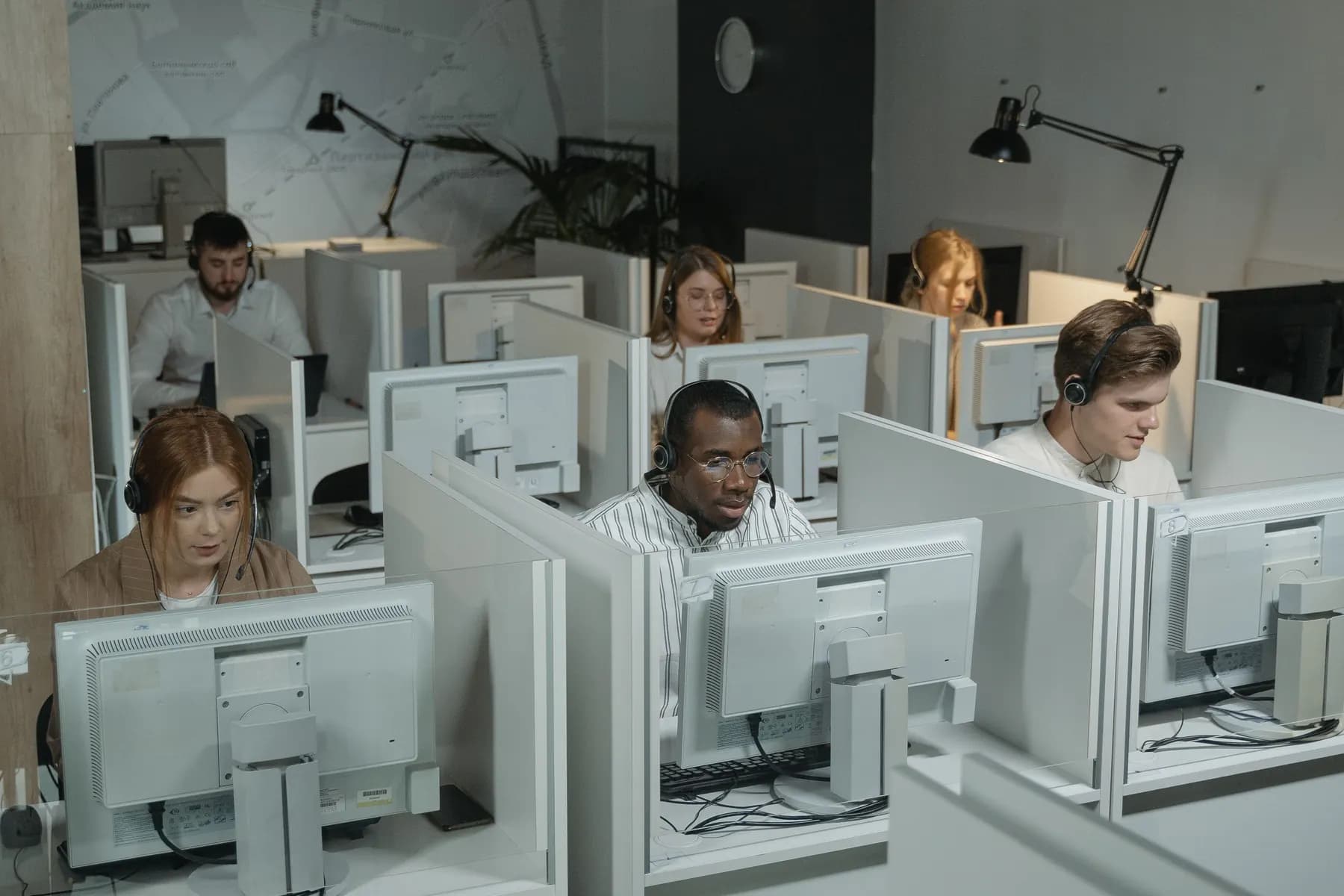 Customer support specialists assisting people from a shared office
